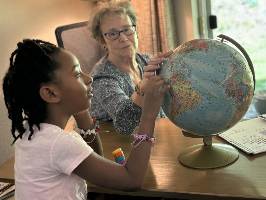 Carola and student studying globe